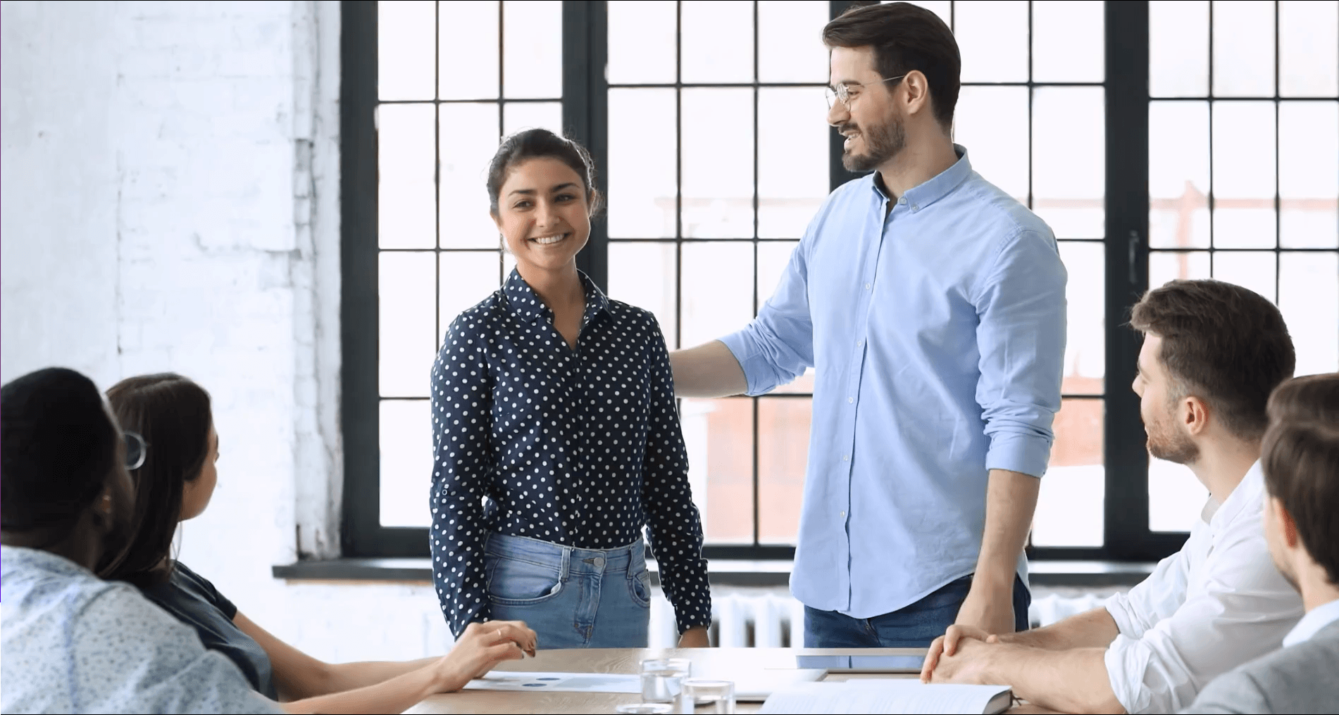 Leidinggevende introduceert een nieuwe collega aan team in devergaderruimte