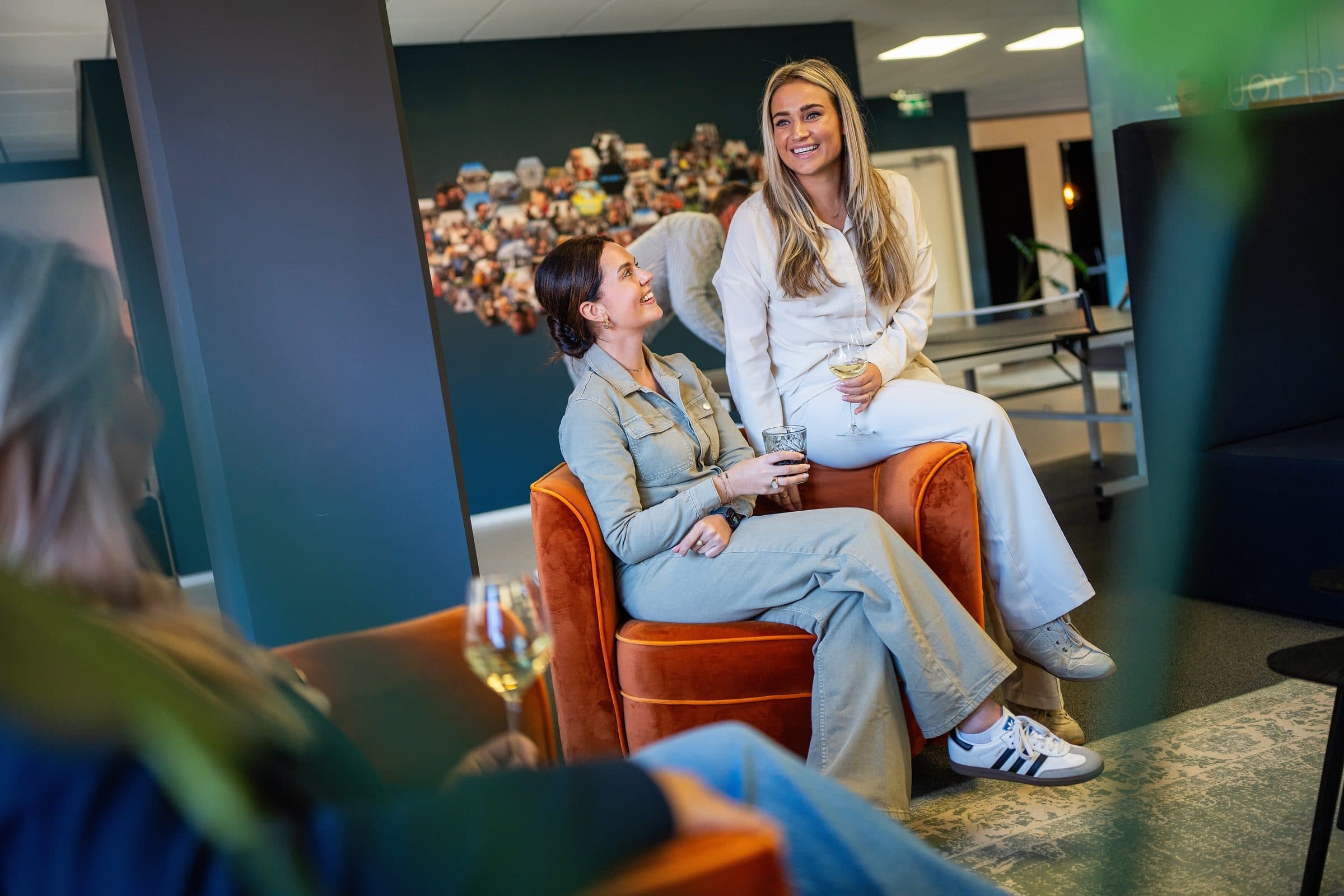Twee collega's lachen samen in de fauteuils op het Work-on kantoor