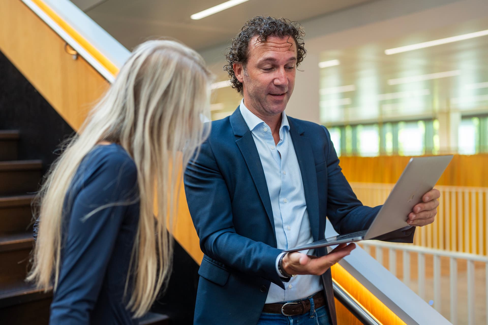 Vrolijke vrouw gebruikt laptop in een lichte kantoorruimte en kijkt aandachtig naar haar scherm symbolisch voor inzicht in salaris