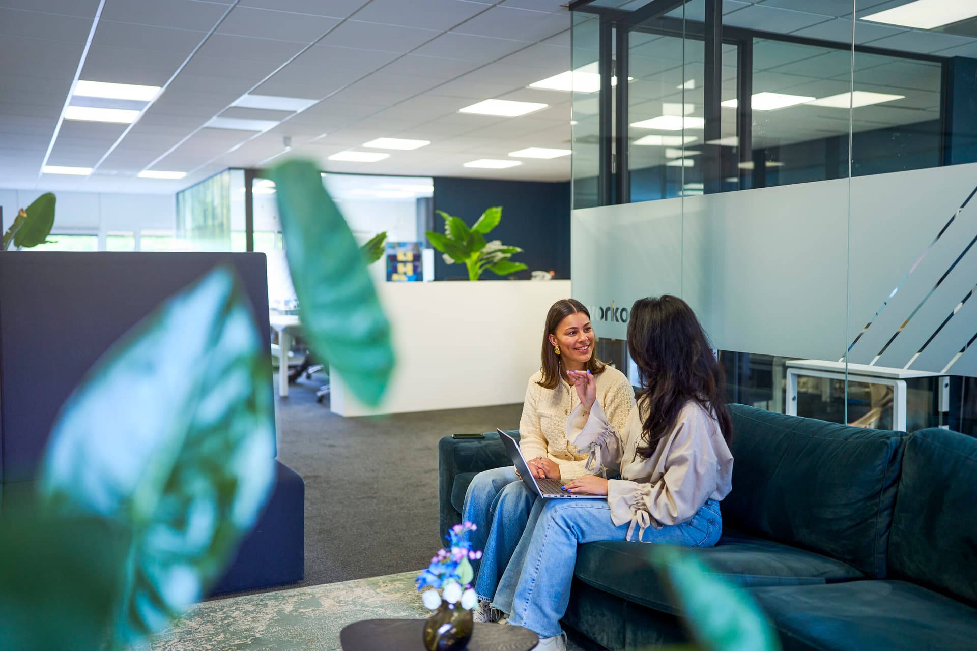 Een vrolijke groep van vijf collega's werkt samen in een voorbeeld van positieve bedrijfscultuur, in een rustige kantooromgeving."