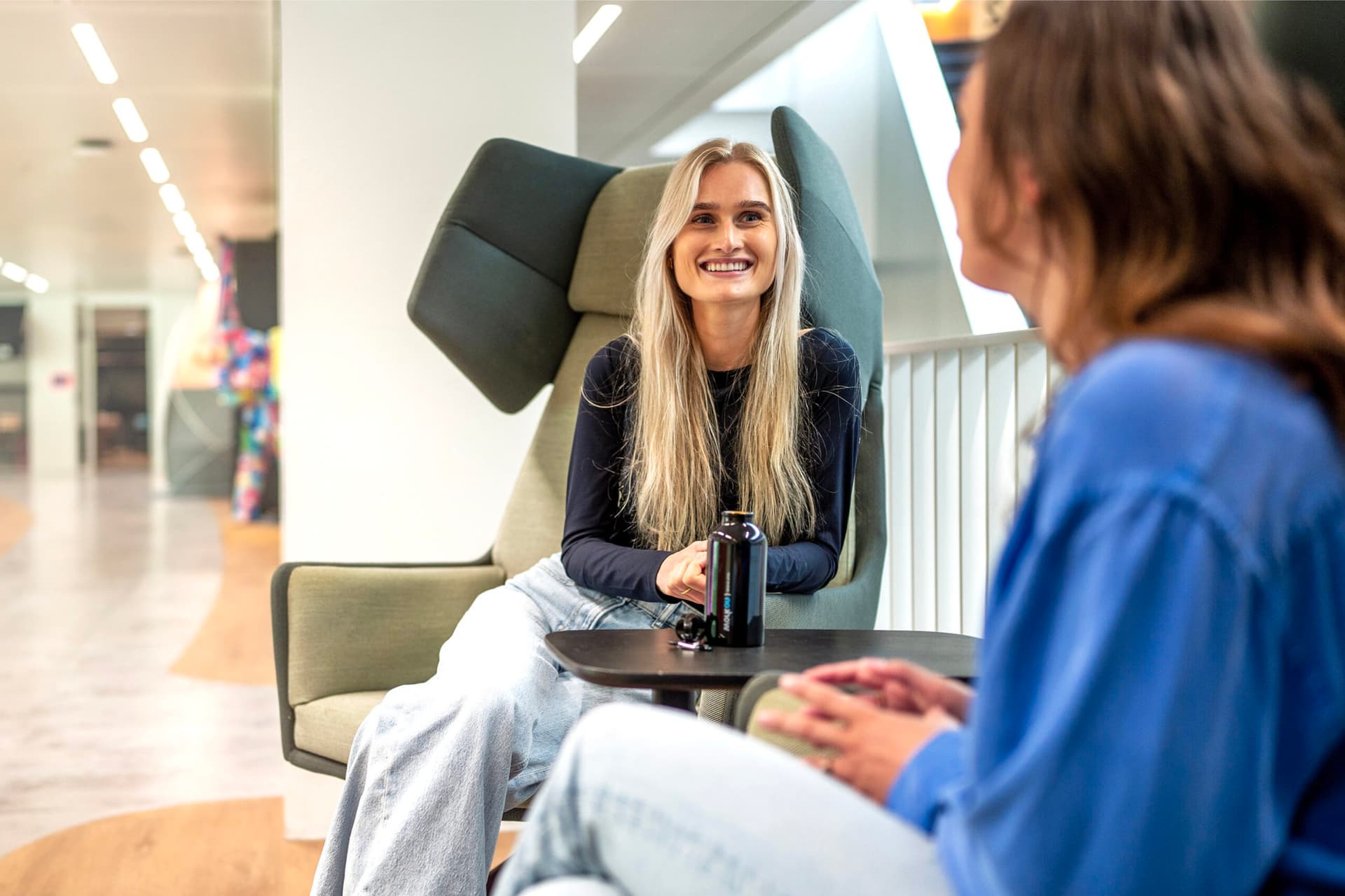 Zelfverzekerde vrouw met armen over elkaar voor haar bureau symbool voor ambitieus zijn en professionaliteit